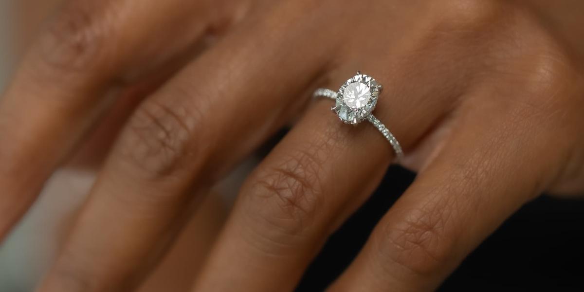 Woman wearing an oval diamond halo engagement ring