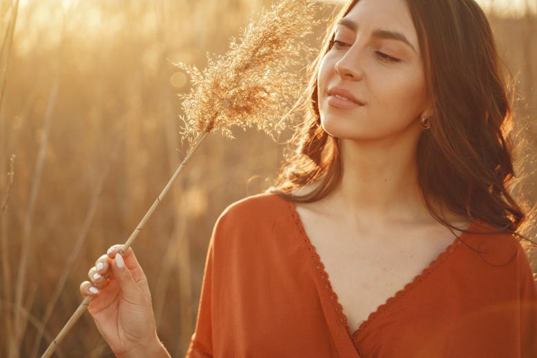 woman standing in fielt at sunset 