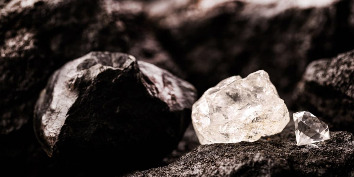 Rough diamond next to a cut diamond, in a coal mine.